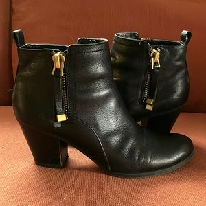 Black leather boots with gold zipper detail